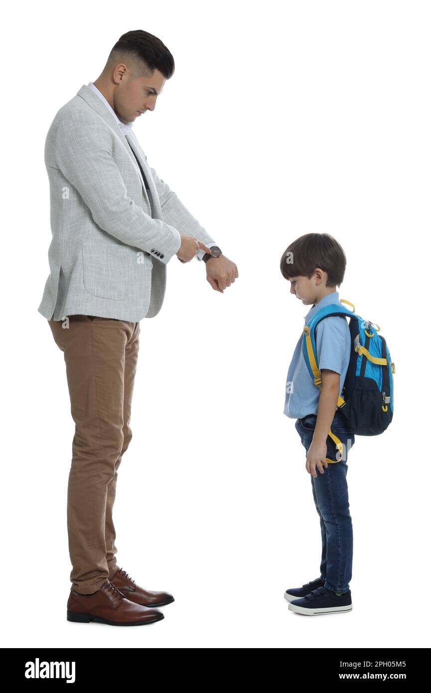 Teacher pointing on wrist watch while scolding pupil for being late against white background Stock Photo