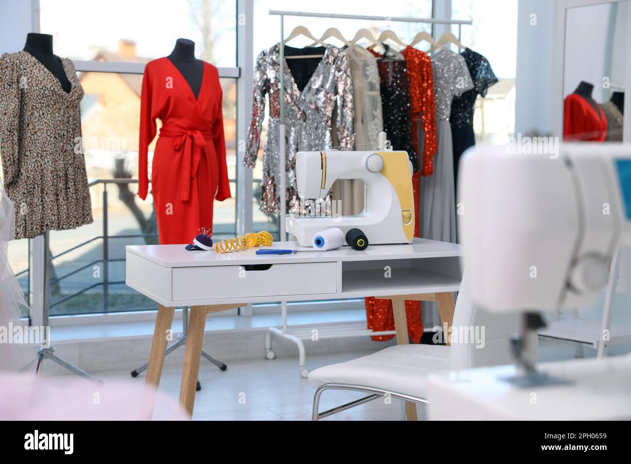 Dressmaking interior with stylish female clothes and equipment