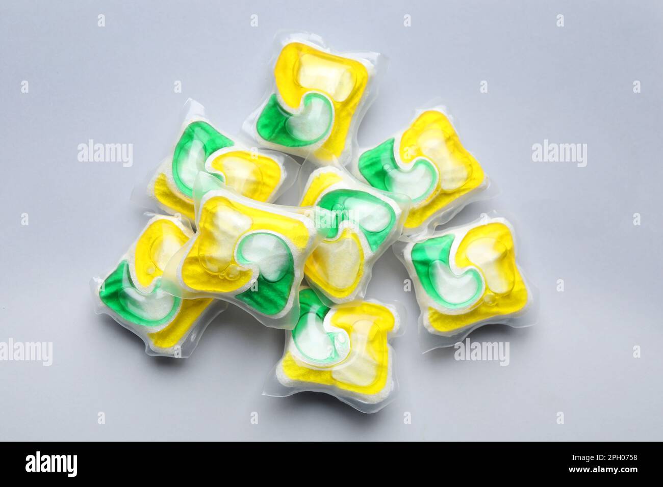 Many dishwasher detergent pods on light grey background, flat lay Stock
