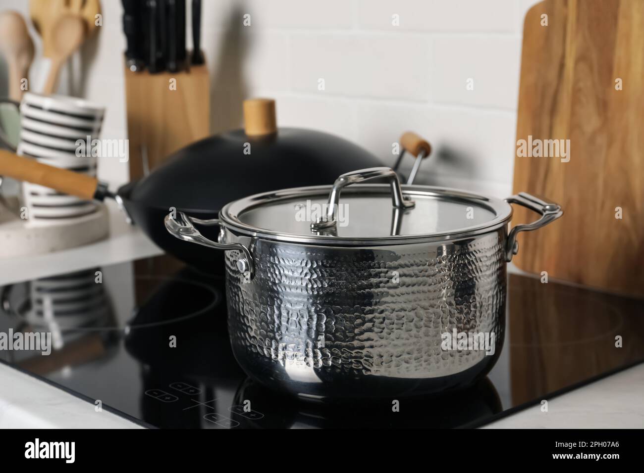 https://c8.alamy.com/comp/2PH07A6/metal-pot-and-wok-on-cooktop-in-kitchen-closeup-cooking-utensils-2PH07A6.jpg