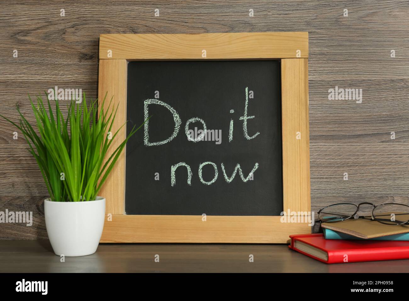 Small chalkboard with motivational quote Do It Now, stationery and