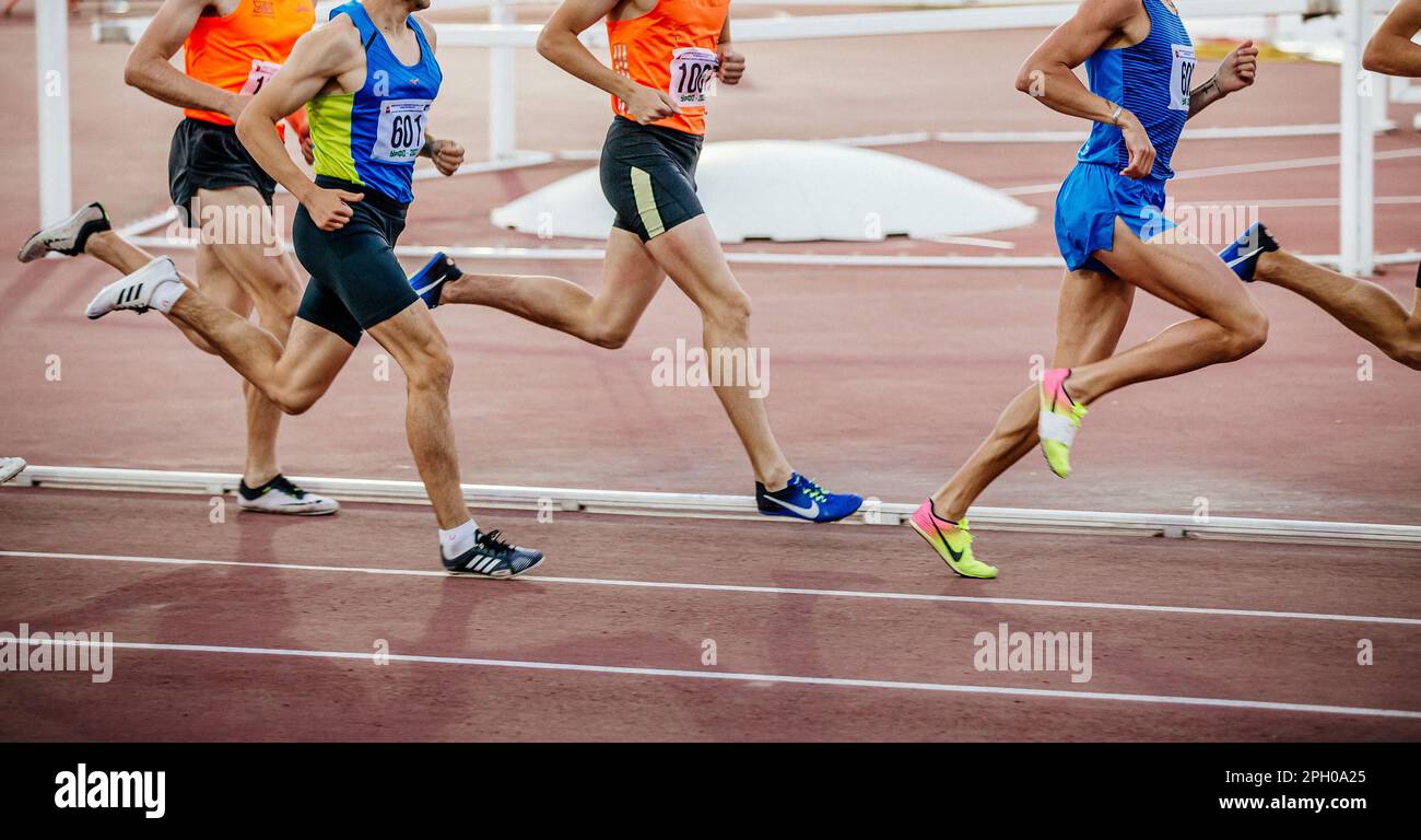 group runners athletes on middle distance run race, Nike and Adidas running  spikes shoes, summer sports games Stock Photo - Alamy