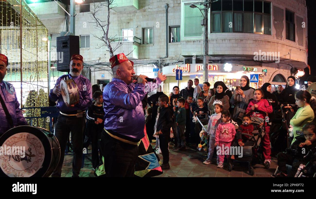 Israeli Arabs gather in the street and watch a traditional Arabic music performance after the break of the Ramadan fast on March 24, 2023 in Jaffa, Israel. Stock Photo