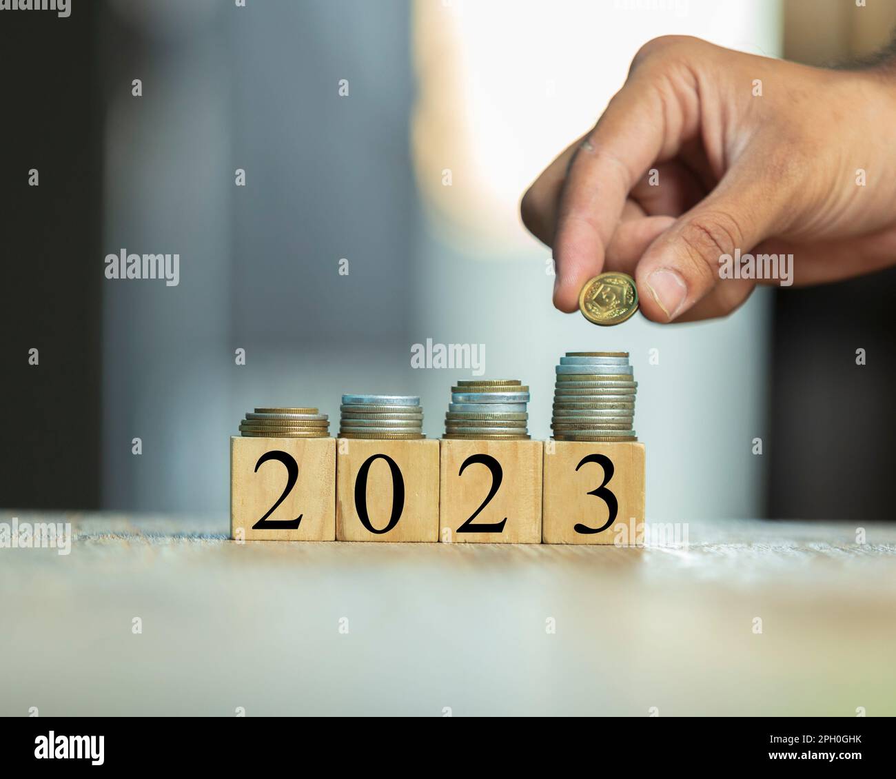 Piled pakistani currency coins and wooden blocks with 2023, growth representation, human hand with coin Stock Photo