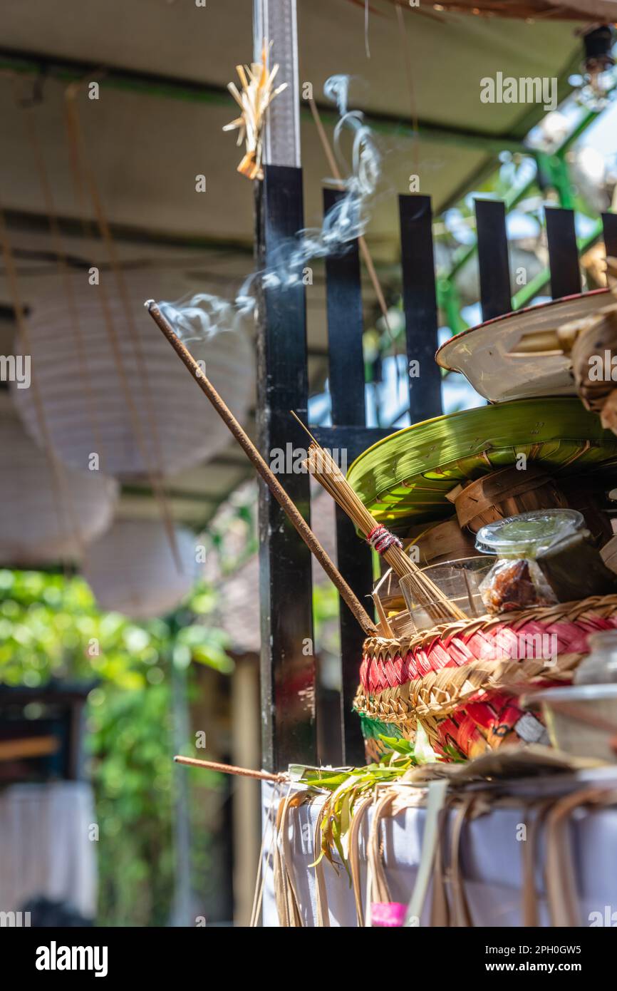 Balinese Hindu altar with offerings and burning incense. Bali