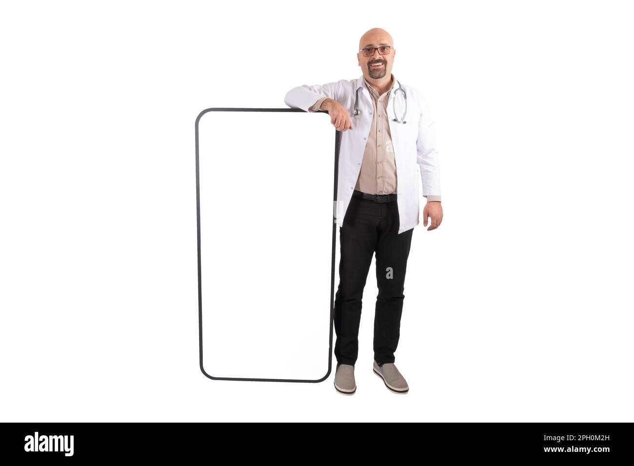 Middle aged caucasian European doctor leaning big smartphone. Isolated white background. Empty screen of mobile phone mock up. Medical mobile app. Stock Photo