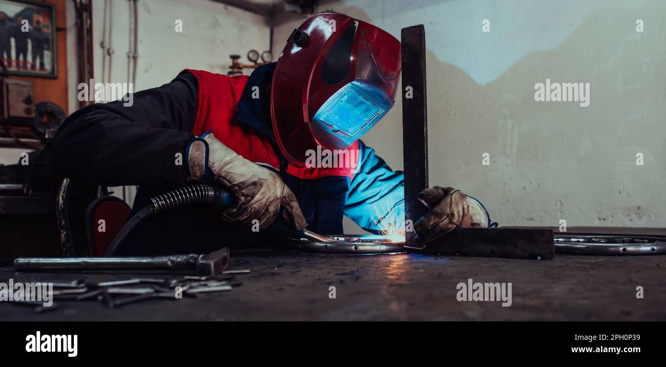 Welder erecting technical steel. Industrial steel welder in factory ...