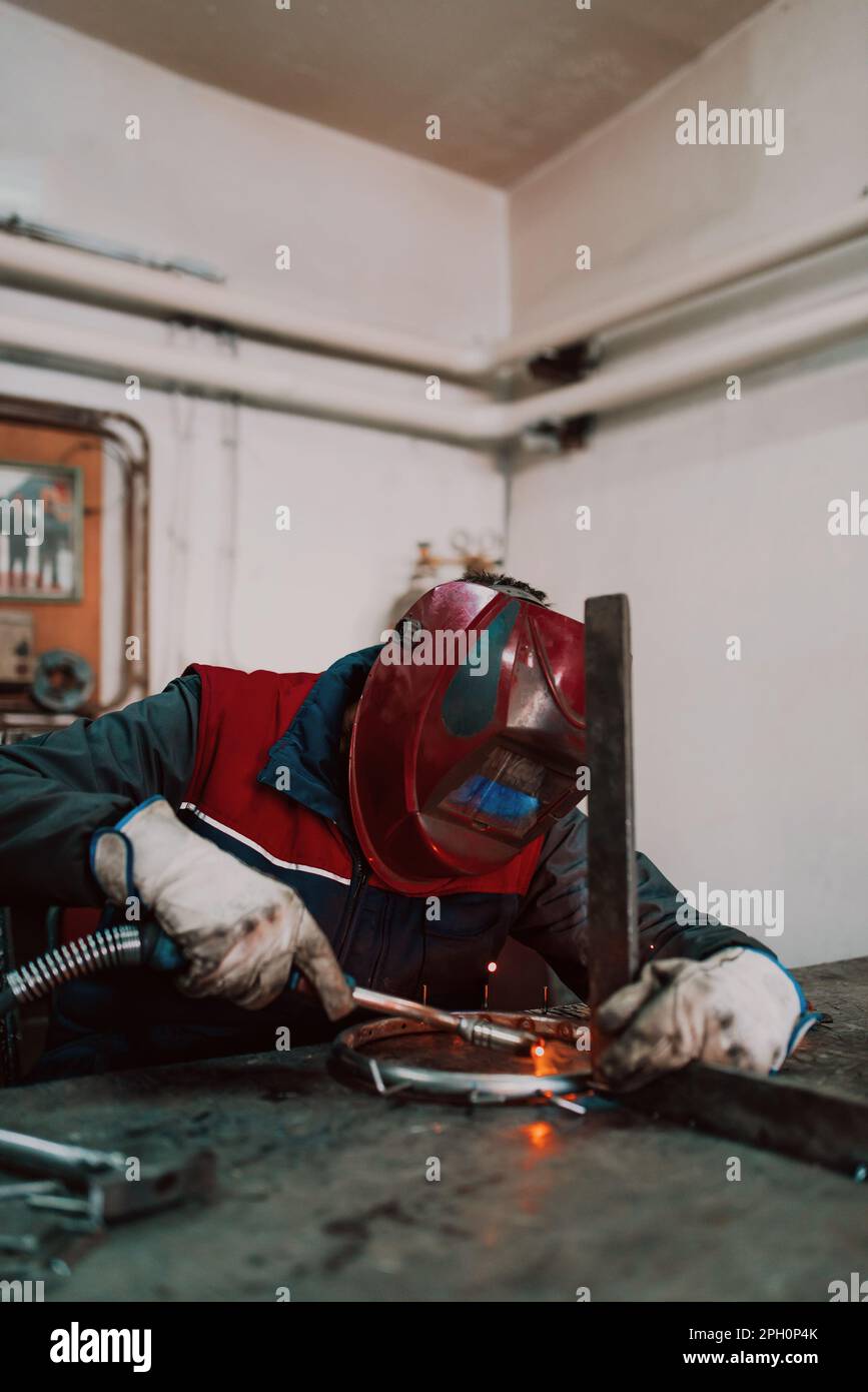 Welder erecting technical steel. Industrial steel welder in factory ...