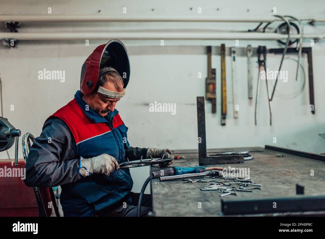 Welder erecting technical steel. Industrial steel welder in factory ...