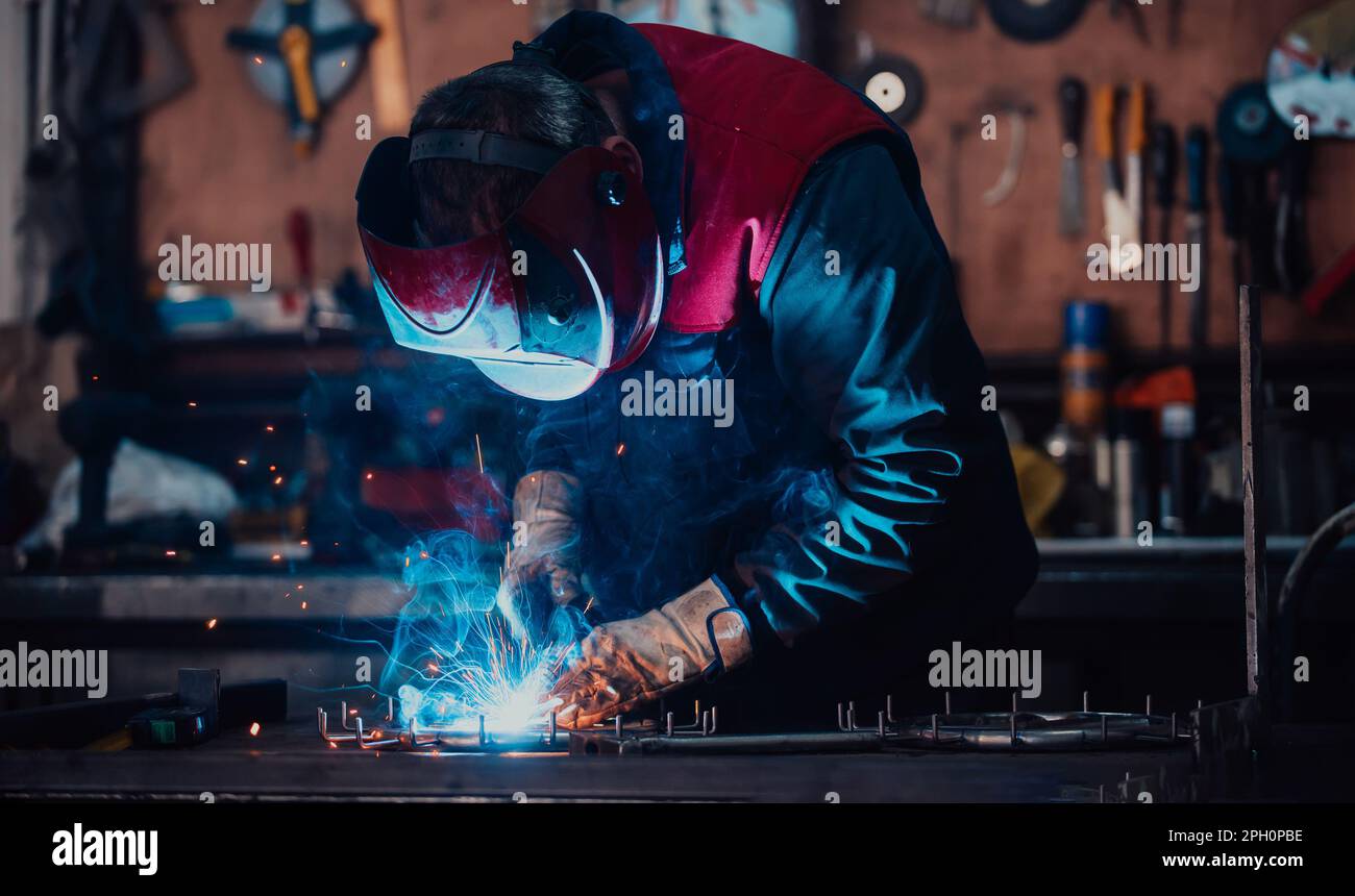 Welder erecting technical steel. Industrial steel welder in factory ...