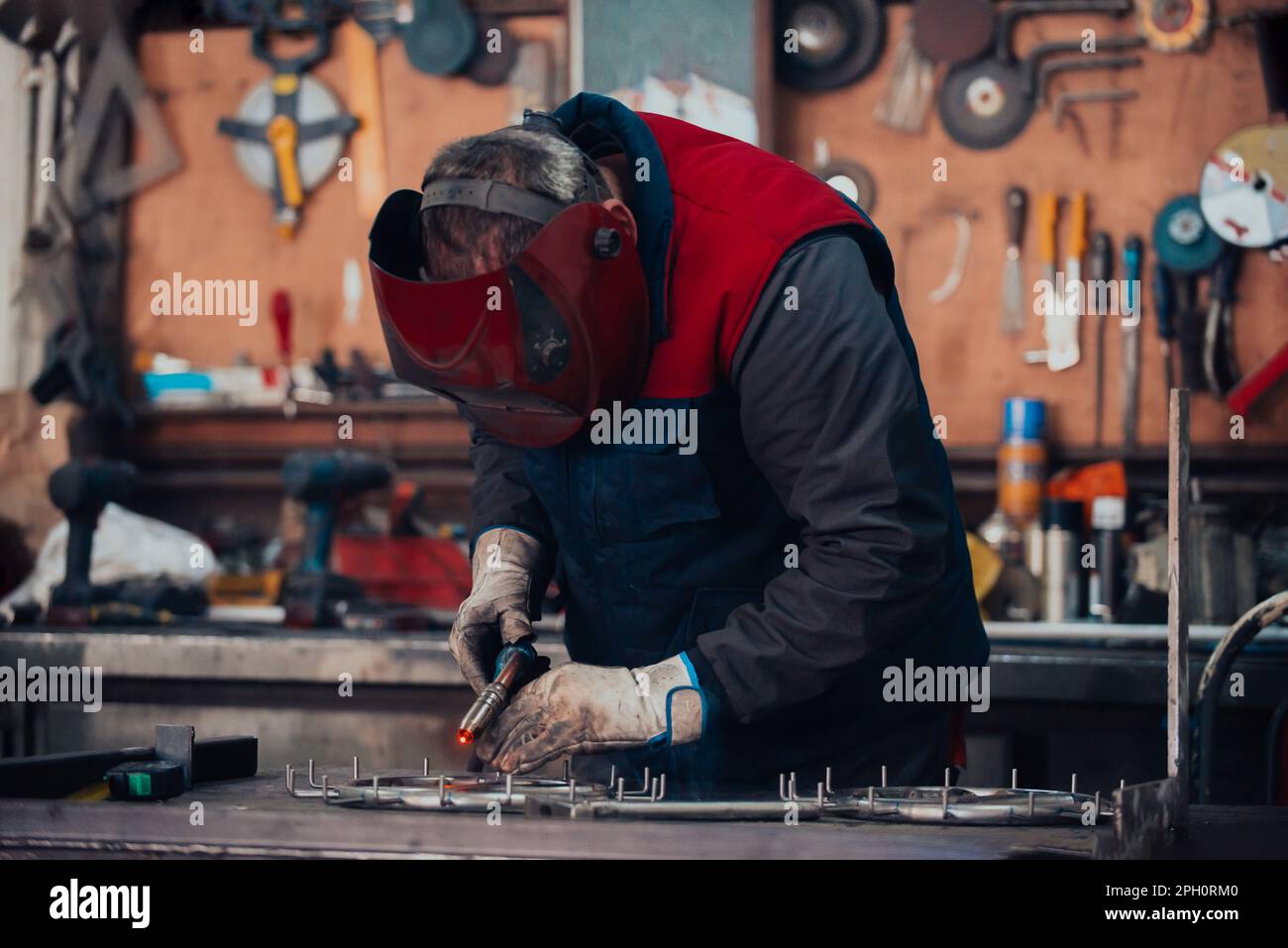 Welder erecting technical steel. Industrial steel welder in factory ...