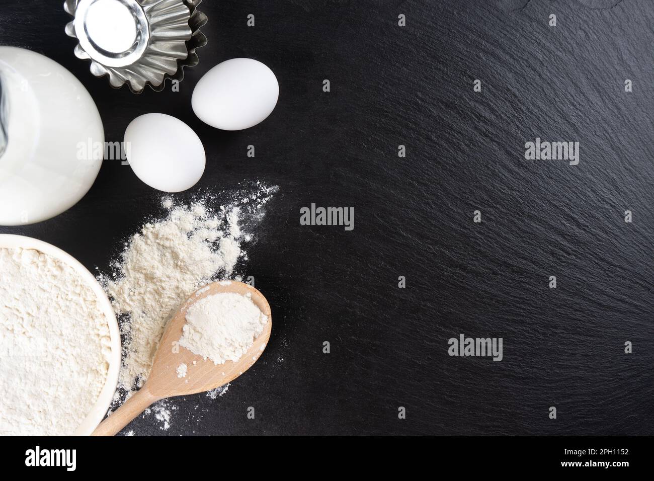 https://c8.alamy.com/comp/2PH1152/baking-cooking-ingredients-background-with-copy-space-flour-eggs-milk-bakeware-on-black-slate-surface-top-view-flat-lay-mockup-menu-banner-he-2PH1152.jpg