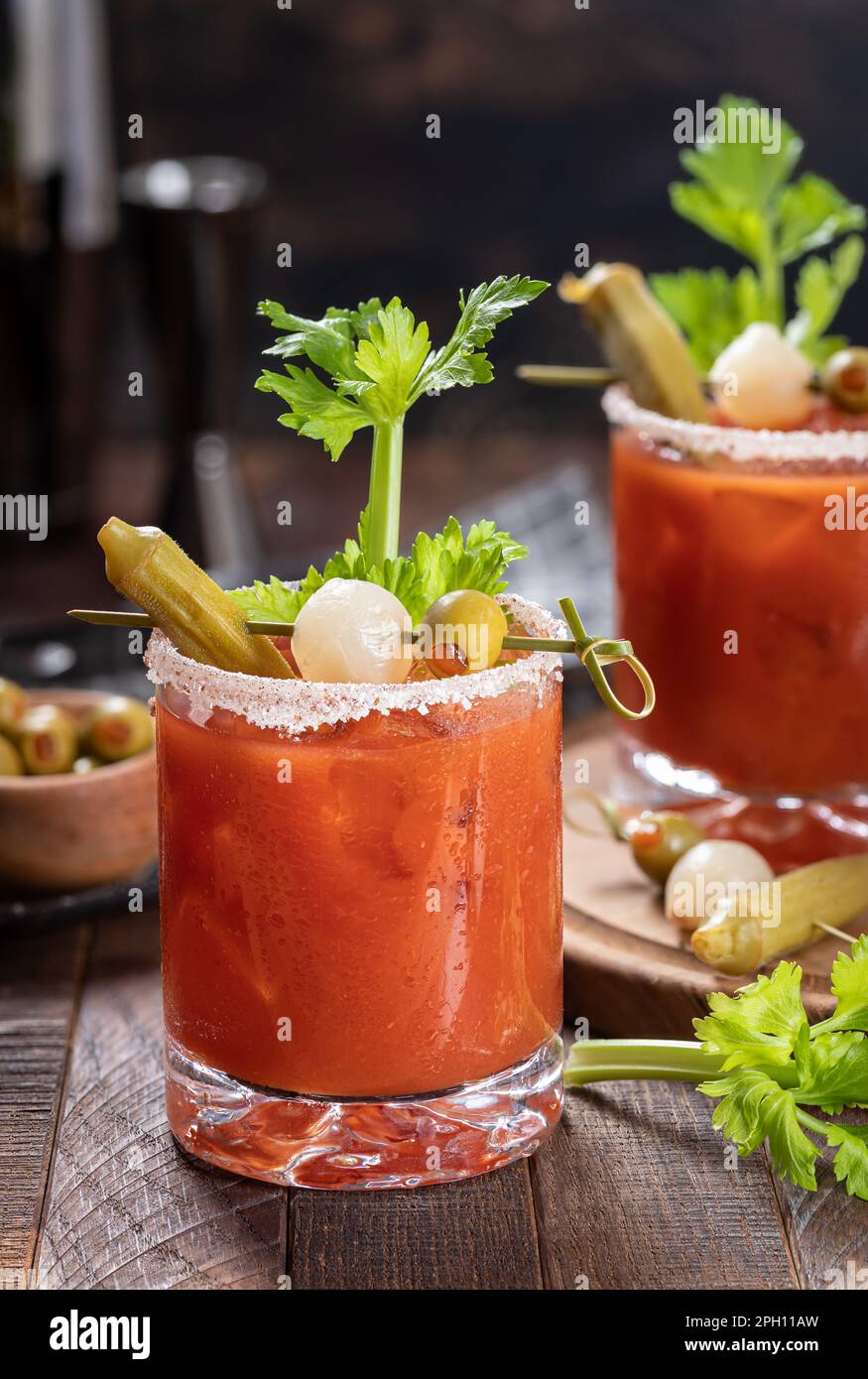 Bloody mary cocktail garnished with celery, okra, onion, olive and salt