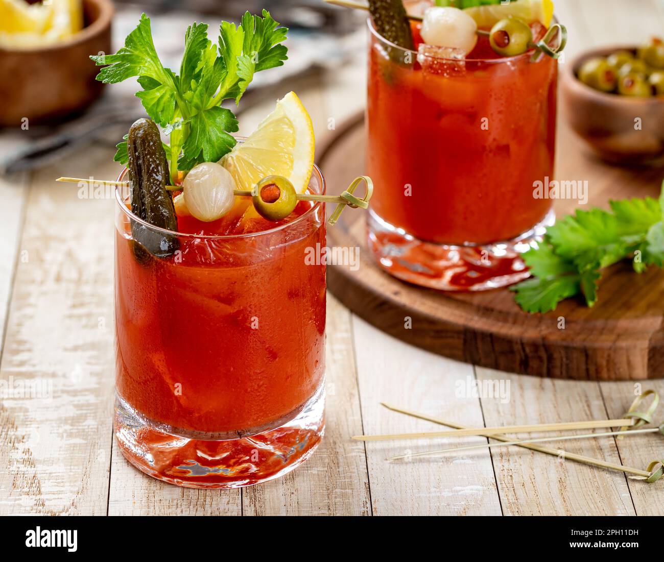 Bloody mary cocktail garnished with celery, lemon, pickle, onion and