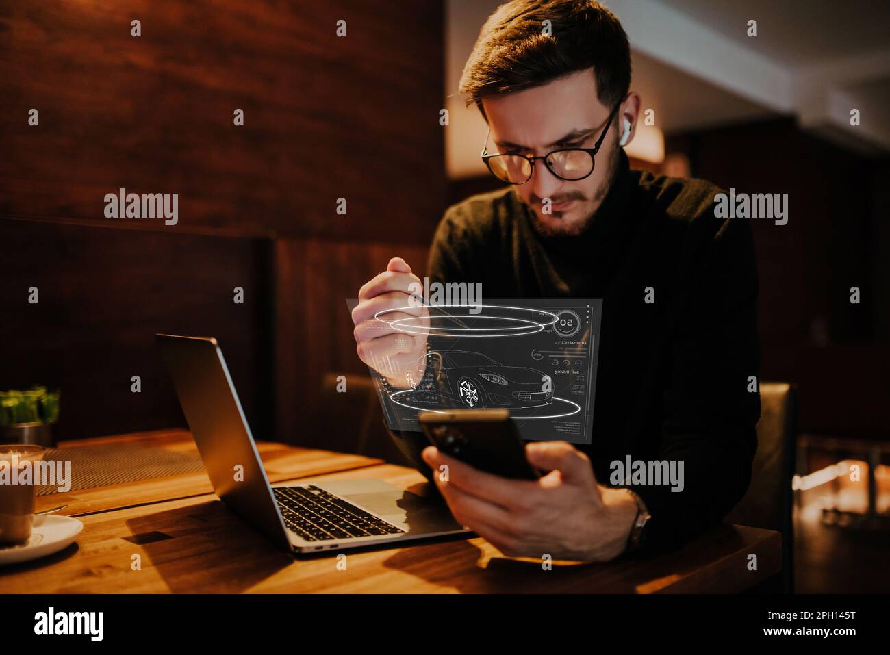 While Viewing An engineer using a smarpthone in a cafe while viewing a hologram of ...