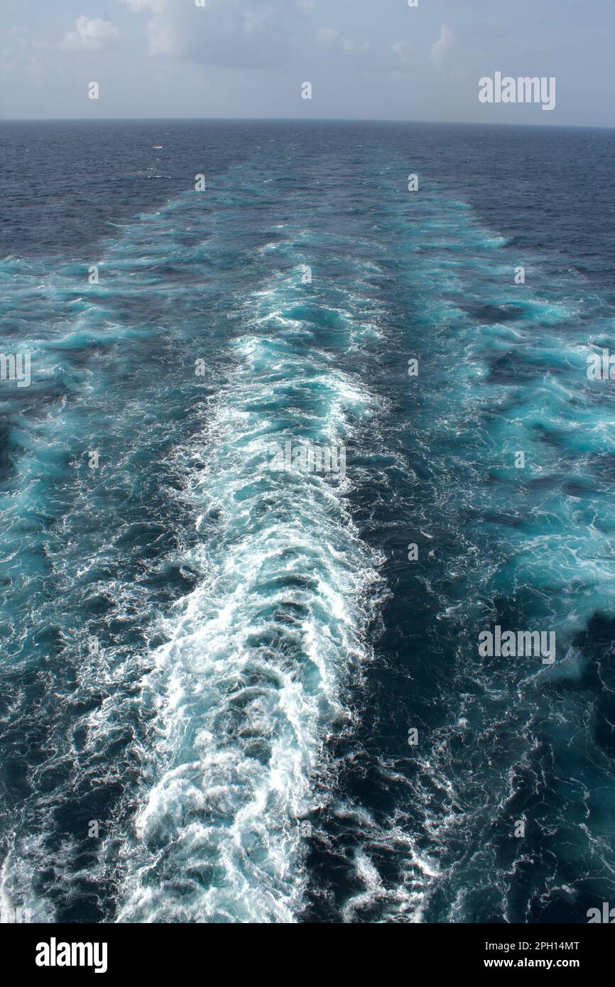 View from the stern of a merchant ship at sea with a clear view of waves from propeller wash Stock Photo