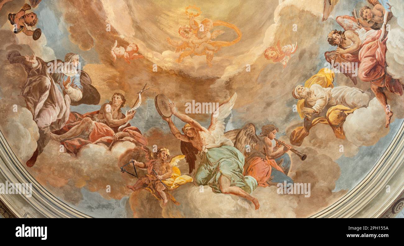 The fresco in baroque cupola - angels with the music instruments and the siants in the church Chiesa dei Santi Gervasio e Protasio Stock Photo