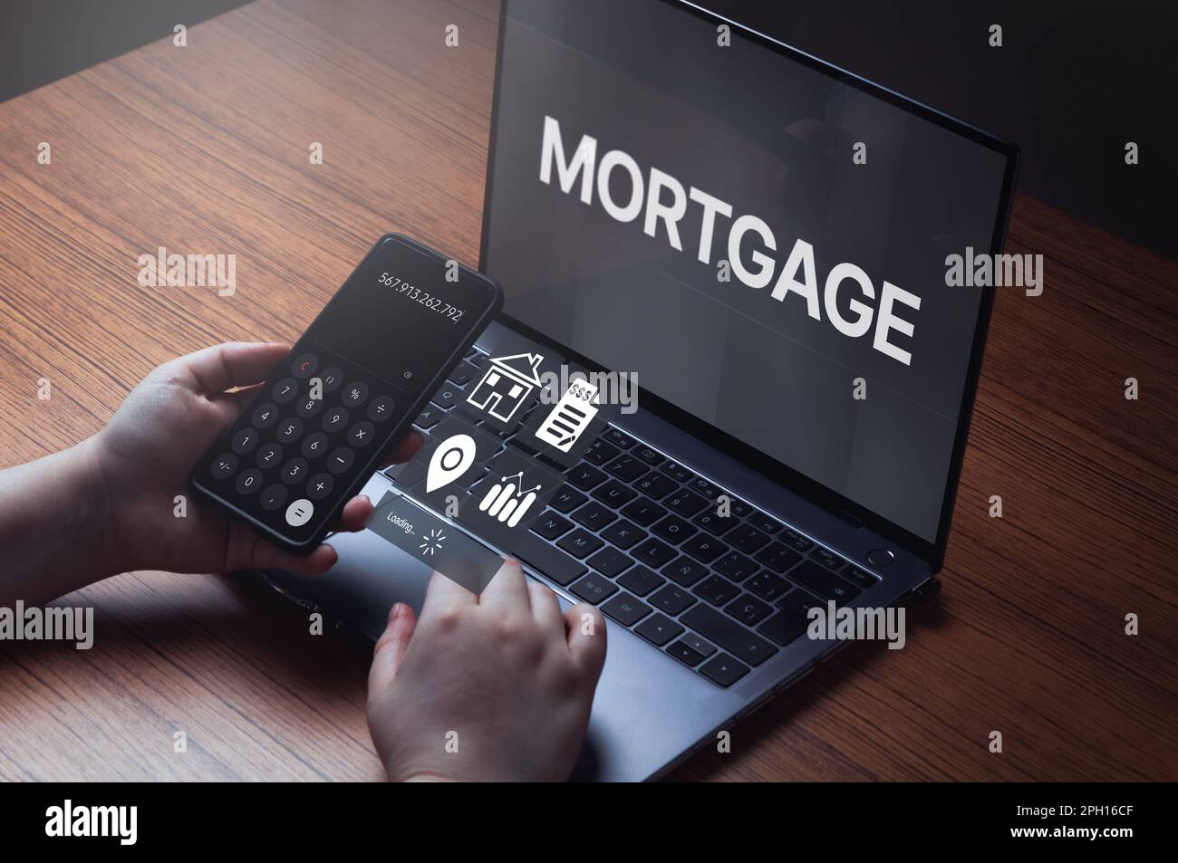 Woman using laptop and smartphone to calculate her mortgage loan. Home mortgage loan concept. Contract for hire purchase and sale a house. Stock Photo