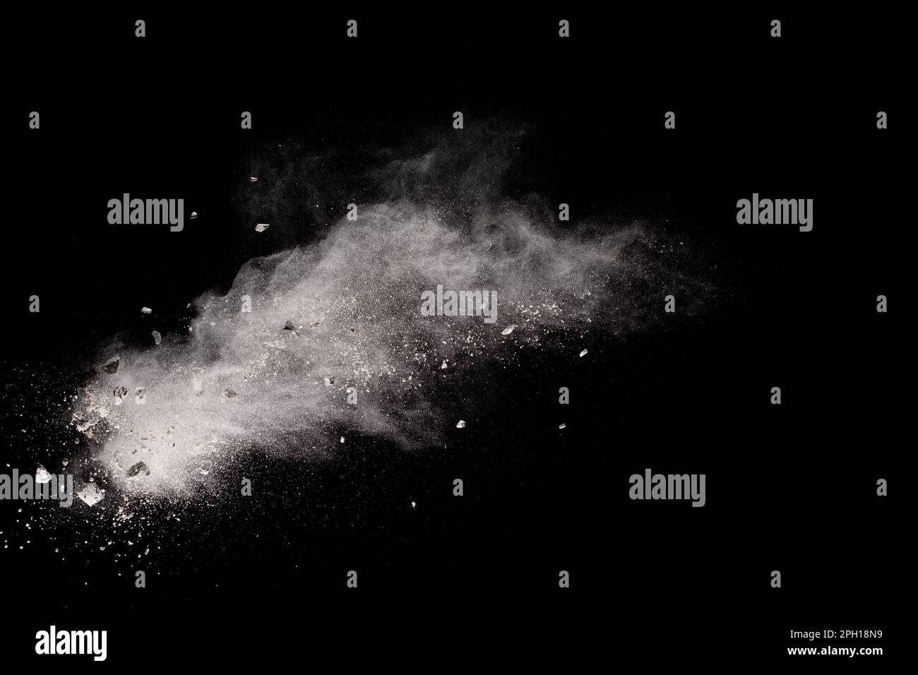Split debris of  stone exploding with white powder against black background. Stock Photo