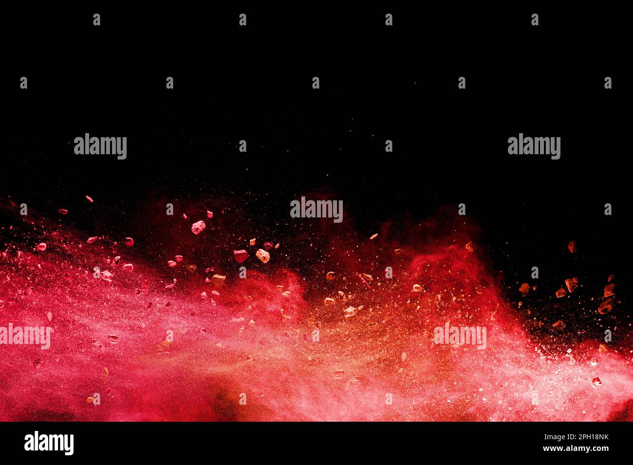 Split debris of  stone exploding with orange powder splash against black background. Stock Photo