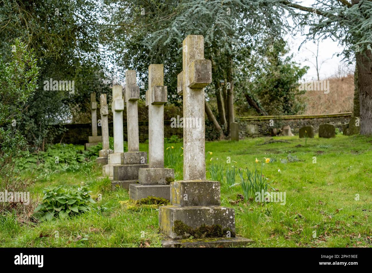 Row of ornate cross headstones in a churchyard with selective focus Stock Photo