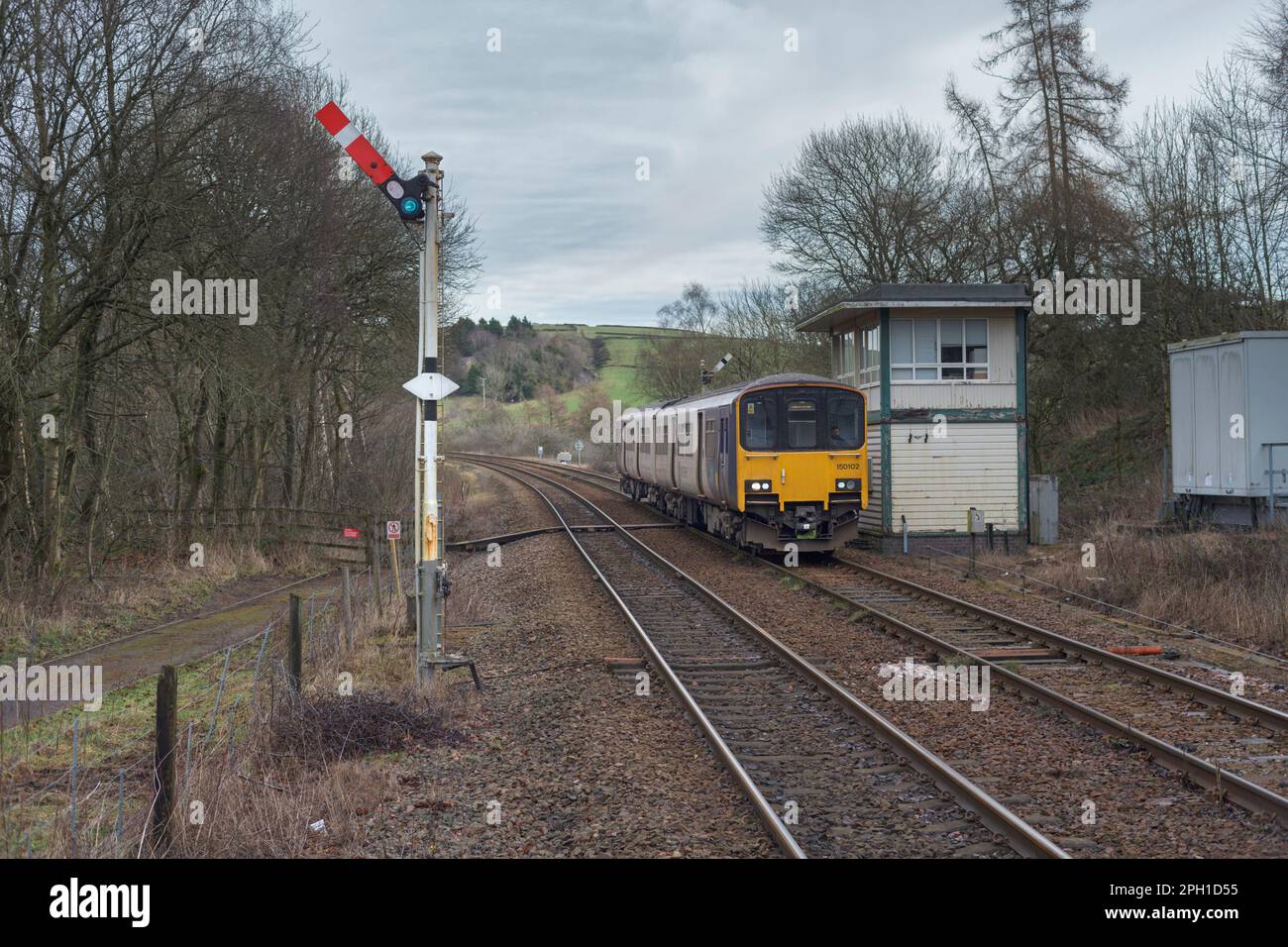 Northern Rail class 150 Diesel multiple unit train 150102 passing the mechanical signal box and semaphore signals at Chapel-En-Le-Frith, Derbyshire Stock Photo