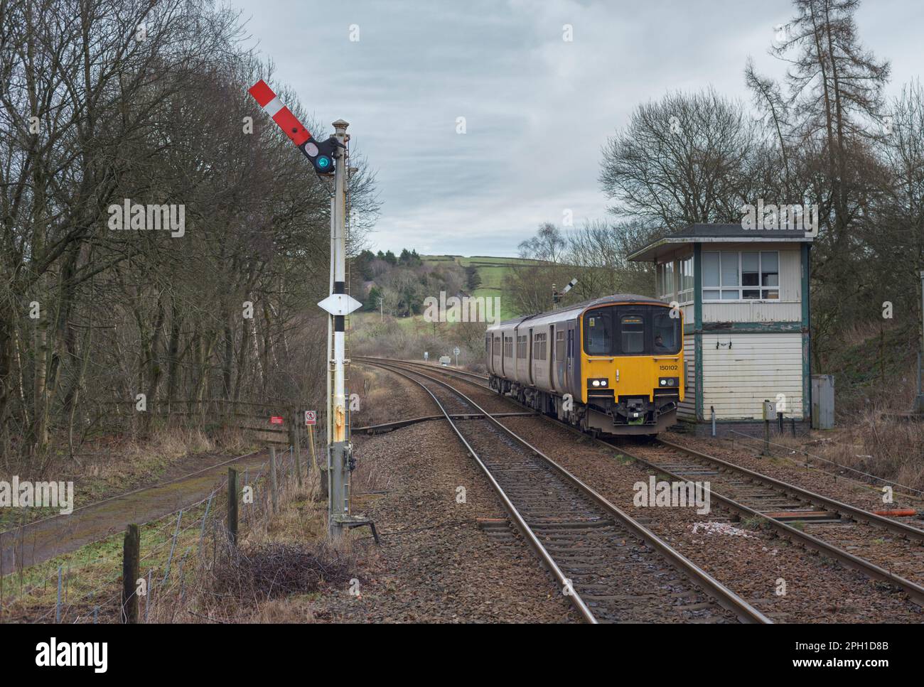 Northern Rail class 150 Diesel multiple unit train 150102 passing the mechanical signal box and semaphore signals at Chapel-En-Le-Frith, Derbyshire Stock Photo