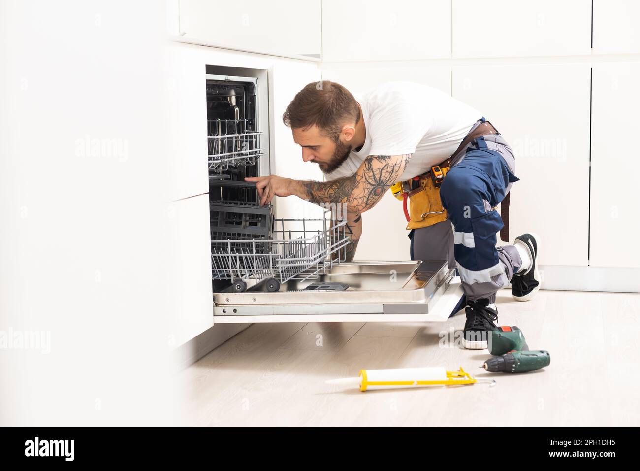 Professional worker estimating cost for broken dishwasher Stock Photo Alamy