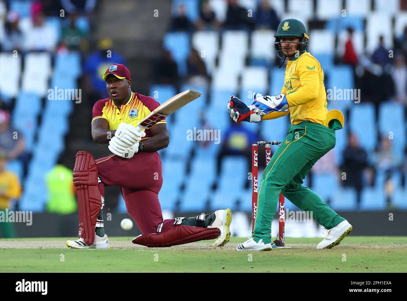 Cricket - First Twenty20 - South Africa v West Indies - SuperSport Park Cricket Stadium, Centurion, South Africa - March 25, 2023 West Indies' Rovman Powell in action as South Africa's Quinton de Kock looks on REUTERS/Siphiwe Sibeko Stock Photo
