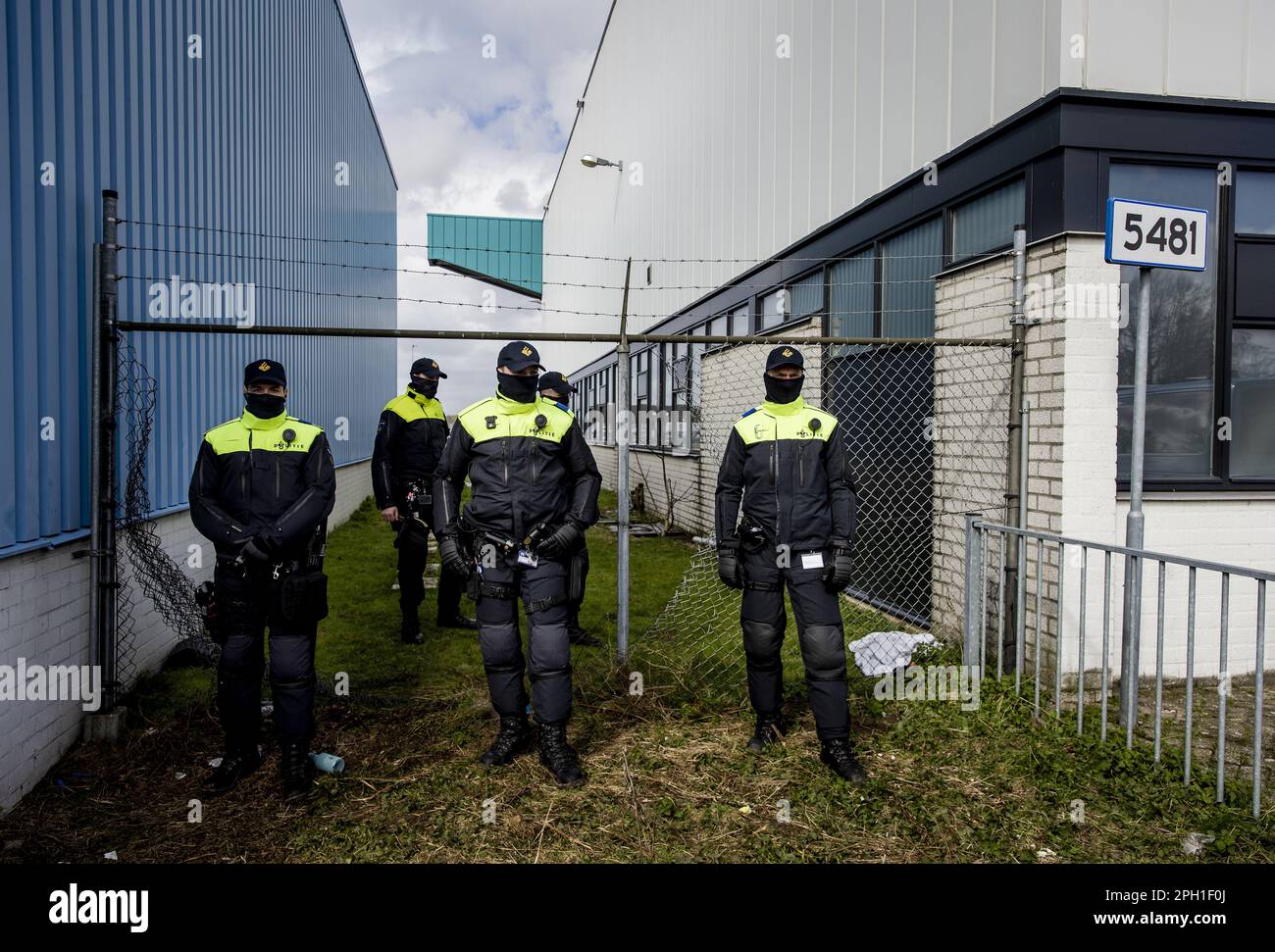 EINDHOVEN - Police officers are lined up in front of the fence in which a hole has been cut by climate activists from Extinction Rebellion during an action at Eindhoven Airport. The activists are very concerned about the damage that air traffic causes to the climate. ANP SEM VAN DER WAL netherlands out - belgium out Stock Photo