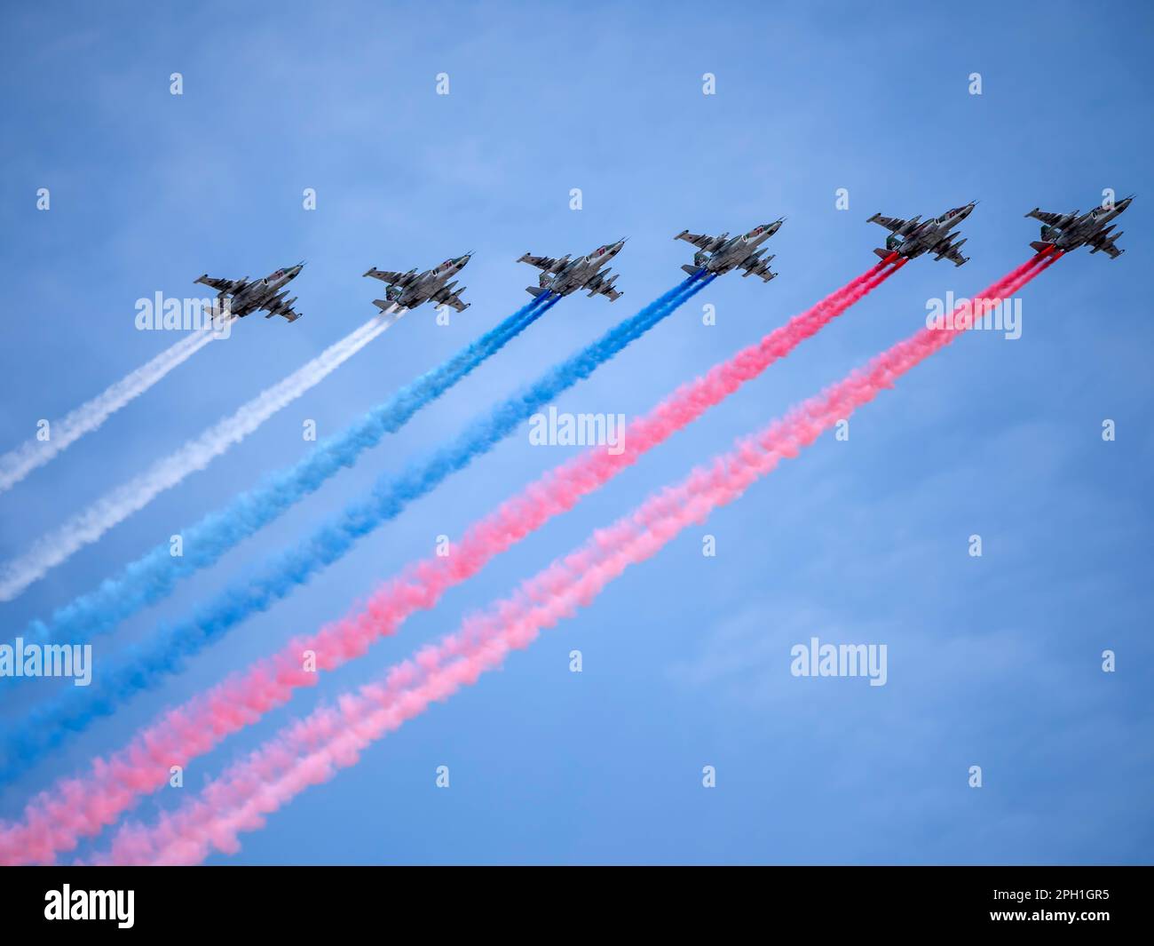 MOSCOW, RUSSIA - MAY 7, 2022: Avia parade in Moscow. Group of Russian fighters Sukhoi Su-25 with painted russian flag in the sky on parade of Victory Stock Photo