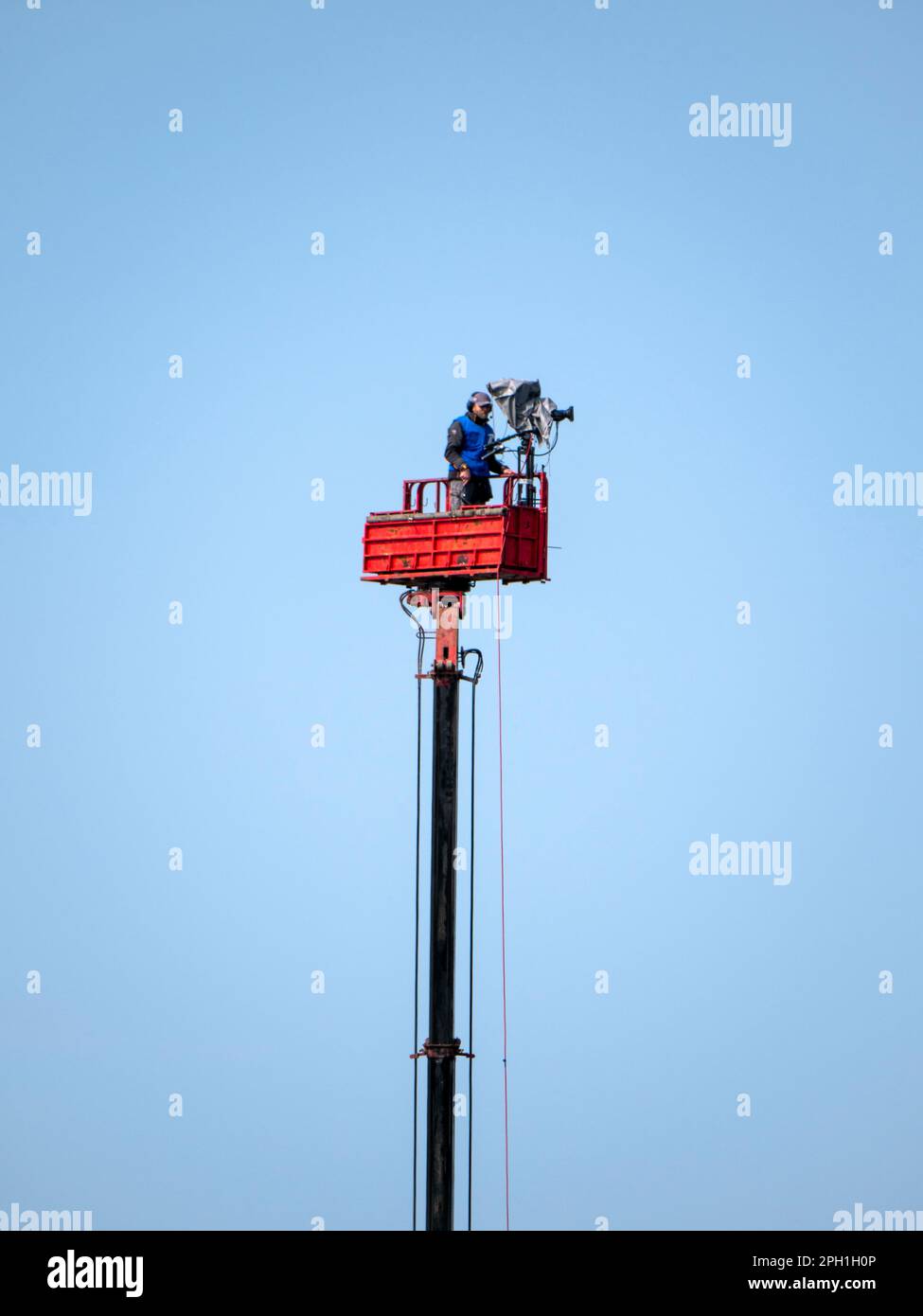 View of a professional camera operator on top of tower for high ground view. Stock Photo