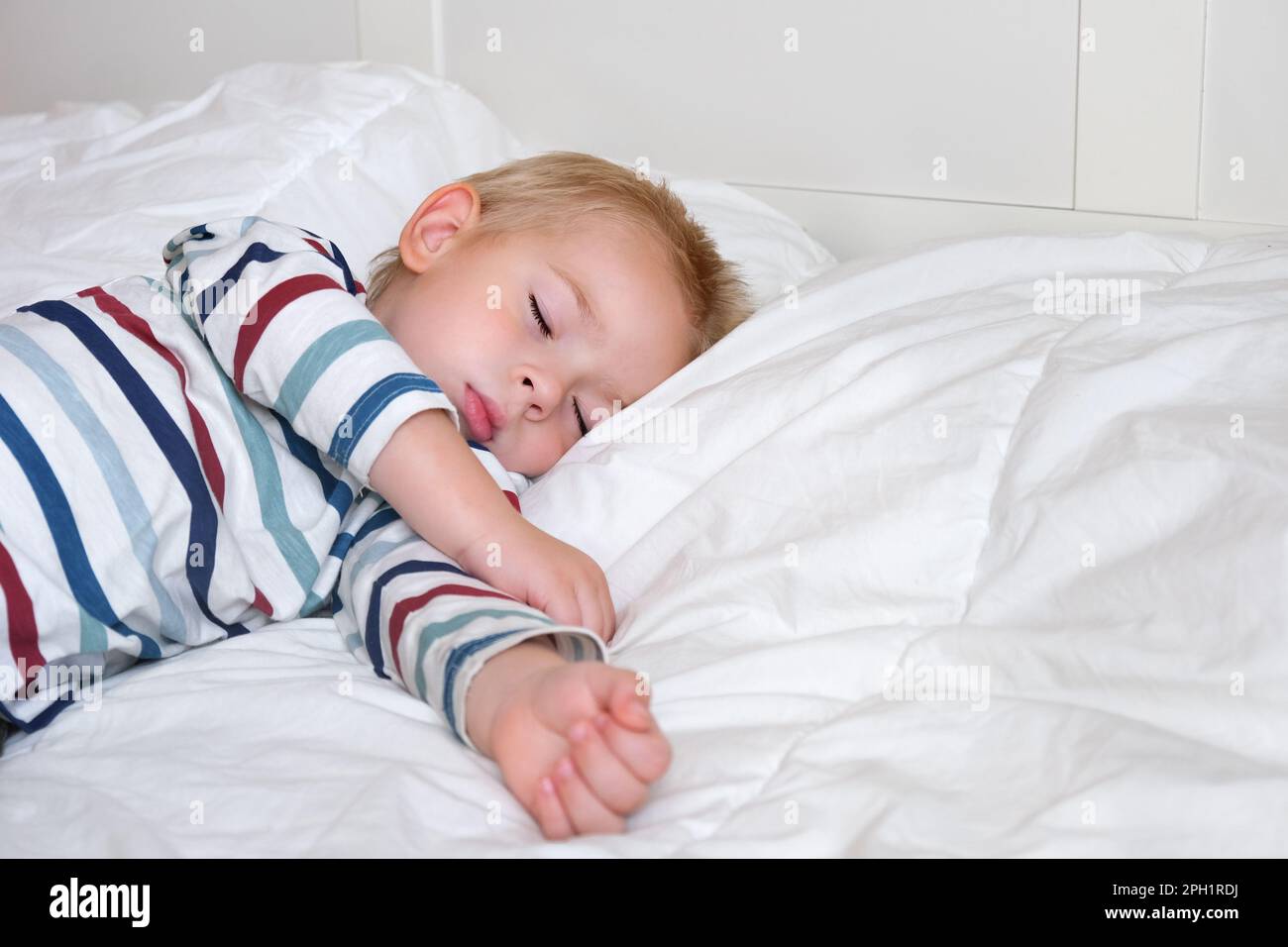 Sleeping Child in Bed. Cute Little Kid Sleeps Sweetly on Cozy White