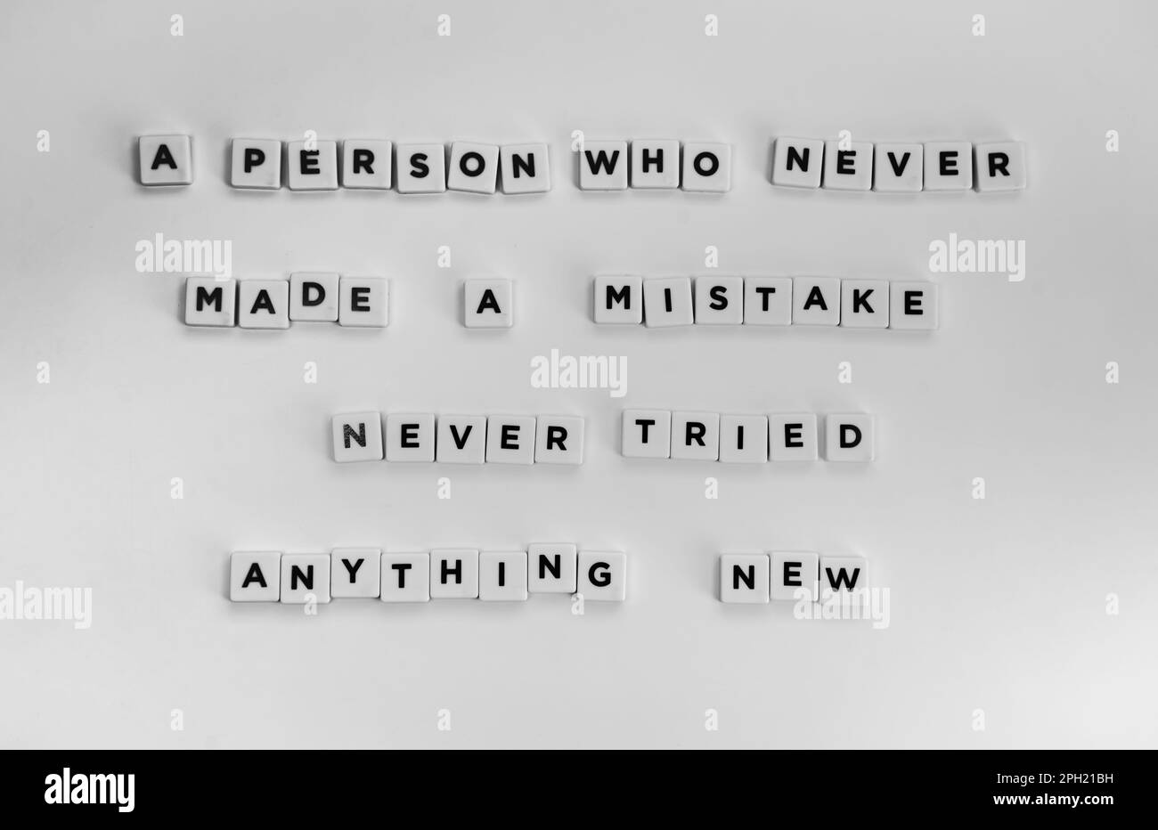 A deep life quote about mistakes written with letter beads on a white surface Stock Photo