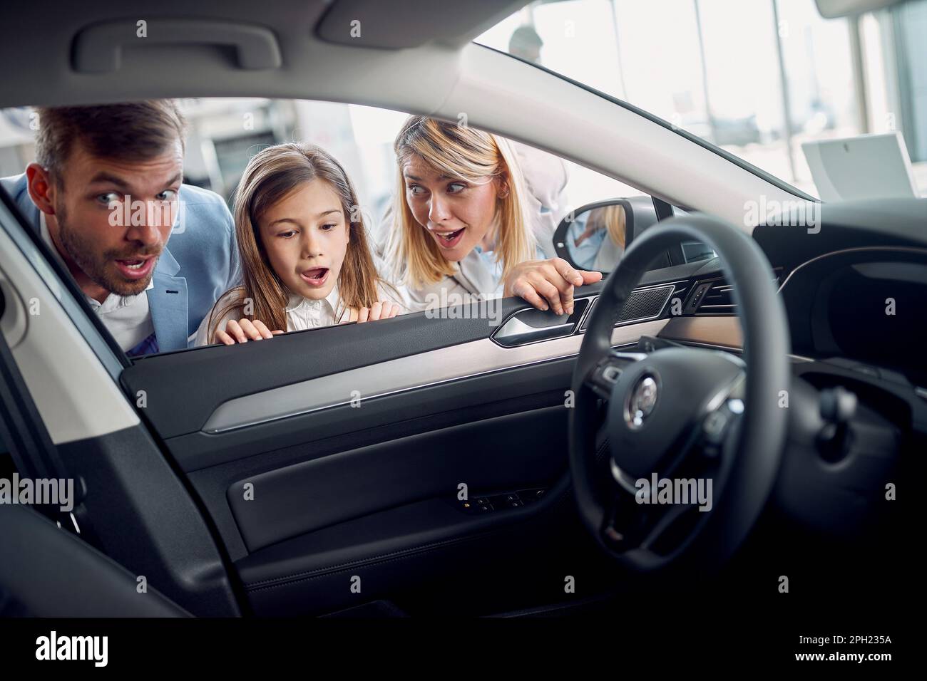 Surpised family watching new car throw window Stock Photo