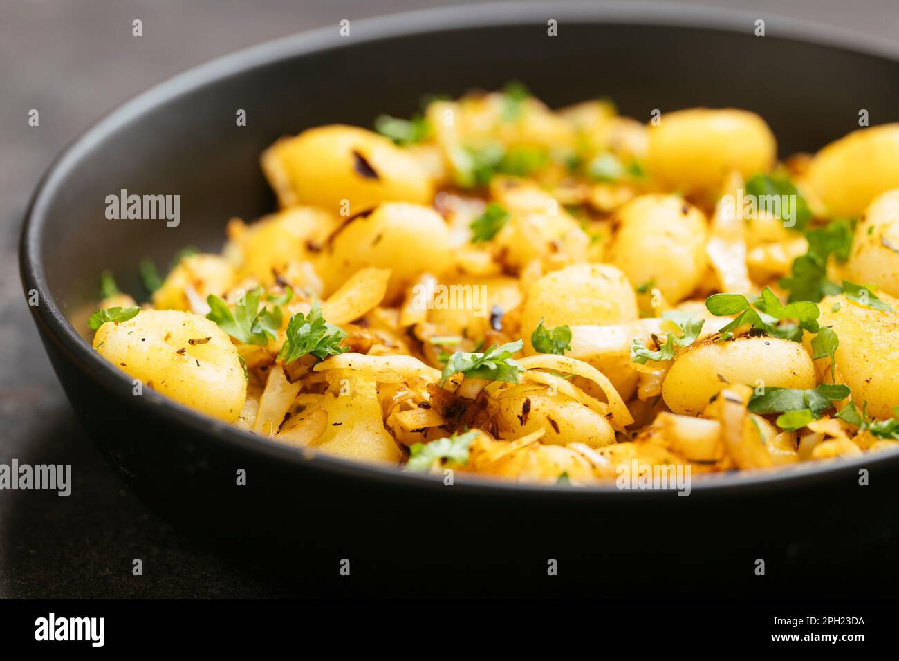 Fried gnocchi with chopped cabbages and cajun spices. Stock Photo