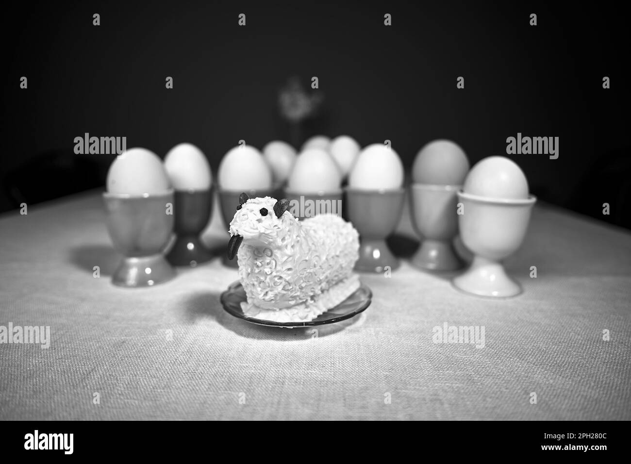 Easter lamb with butter and colorful containers for boiled eggs on the table prepared for Easter breakfast, monochrome Stock Photo
