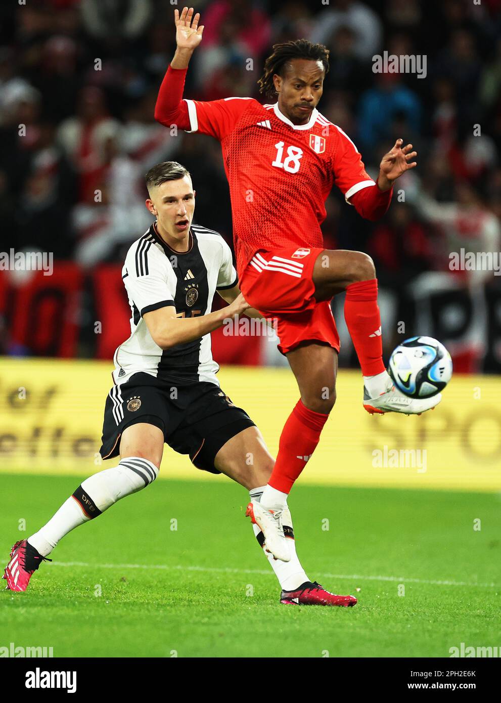 Mainz, Germany. 25th Mar, 2023. Soccer: Internationals, Germany - Peru, Mewa Arena. Germany's Nico Schlotterbeck (l) and Peru's André Carrillo fight for the ball. Credit: Christian Charisius/dpa/Alamy Live News Stock Photo