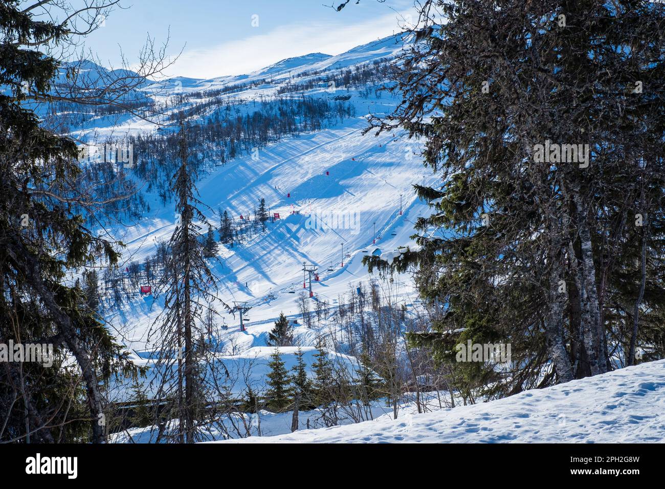 View over ski resort with slopes, chair lifts and majestic snowy mountains during winter day. Stock Photo