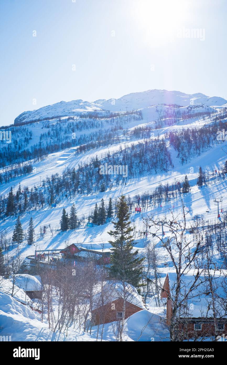 View over ski resort with slopes, chair lifts and majestic snowy mountains during winter day. Stock Photo