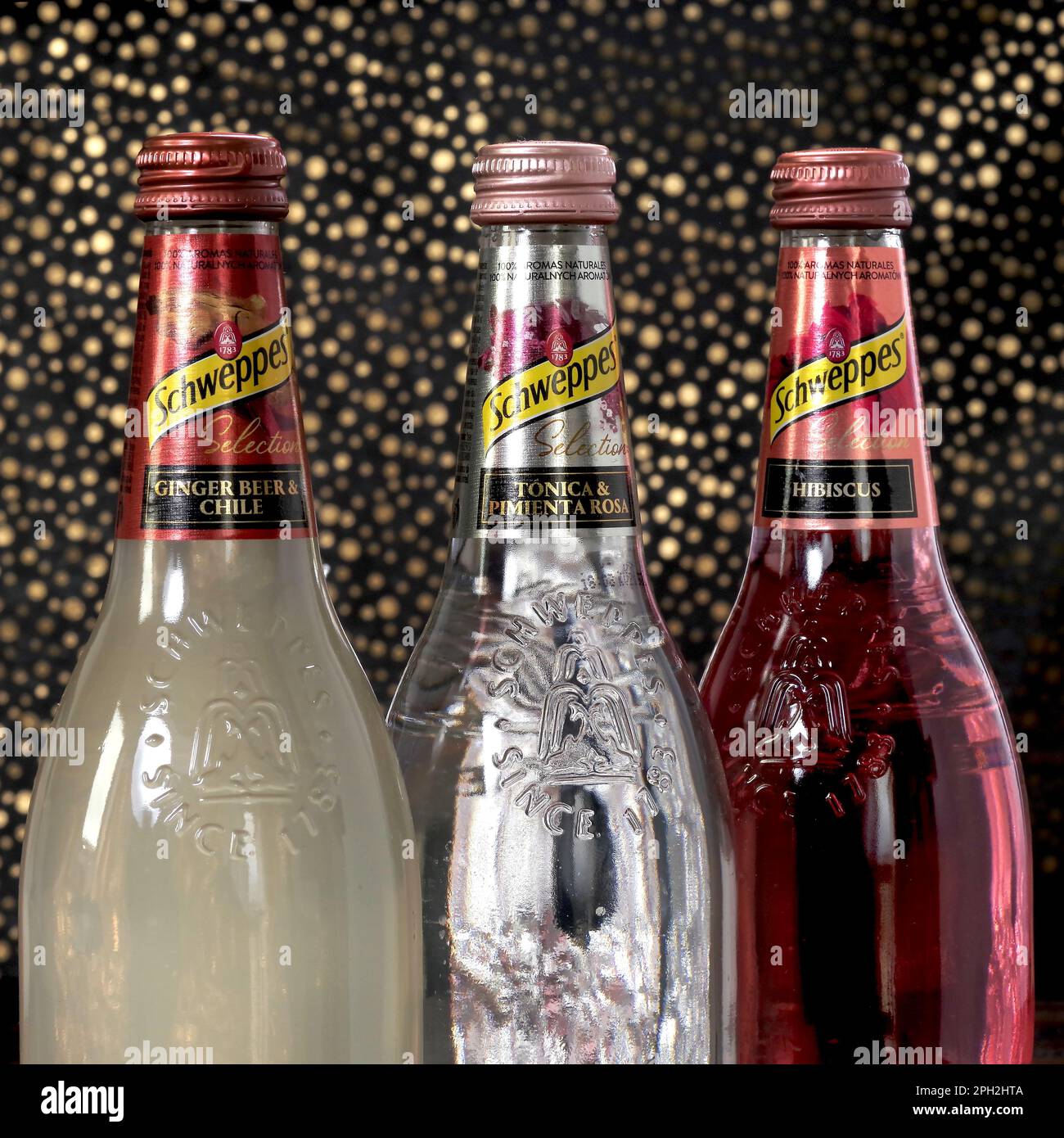 Koszalin, Poland, March 25, 2023. Schweppes Glass bottle on an abstract background. Schweppes logo. Photo of bottles with different flavors of Schwepp Stock Photo