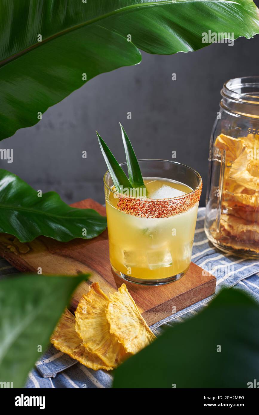 Special cocktail of pineapple, rum and mezcal with garnish chili and