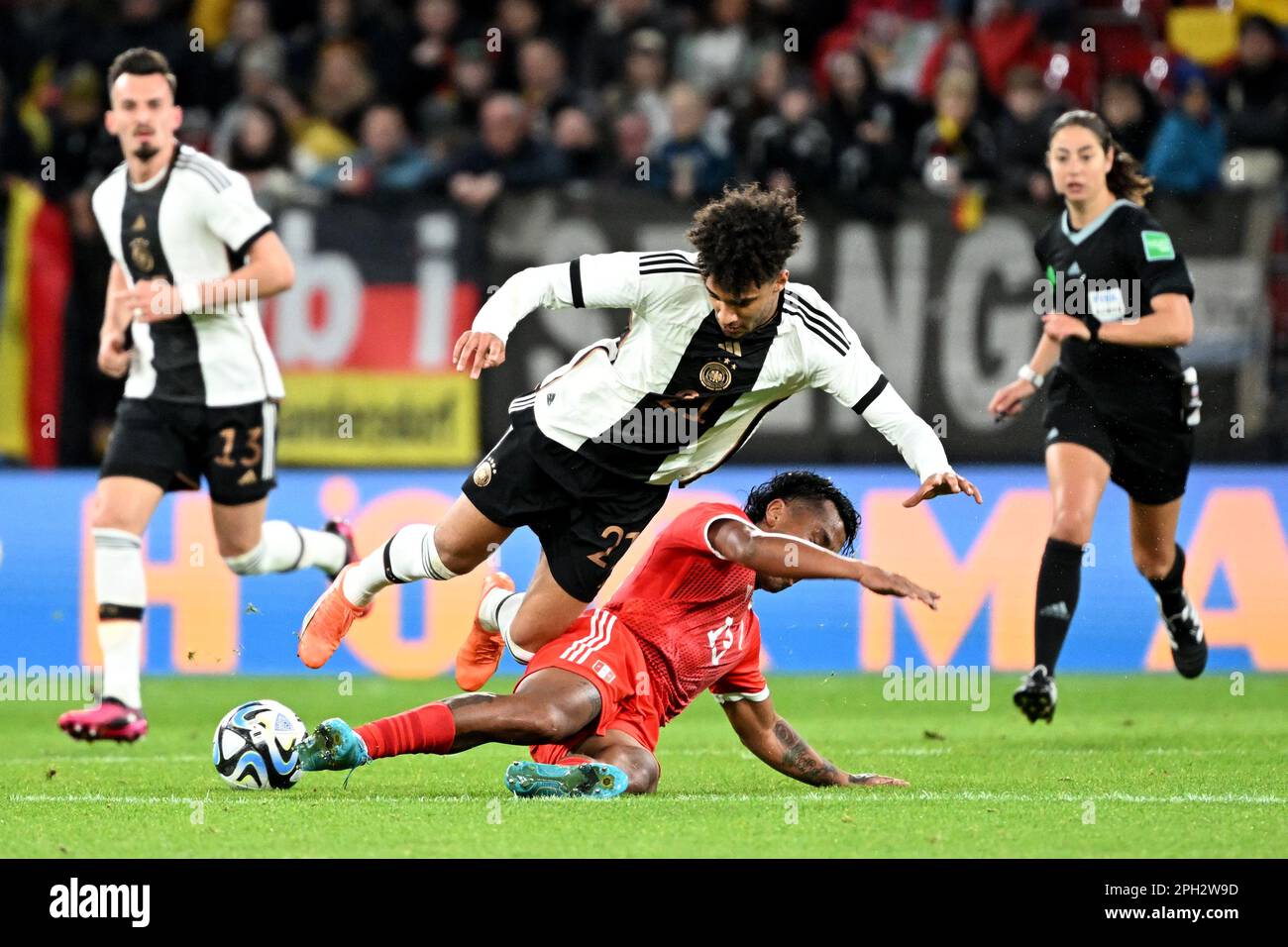 Mainz, Germany. 25th Mar, 2023. Soccer: Internationals, Germany - Peru, Mewa Arena. Germany's Kevin Schade (l) in a duel with Peru's Renato Tapia. Credit: Federico Gambarini/dpa/Alamy Live News Stock Photo
