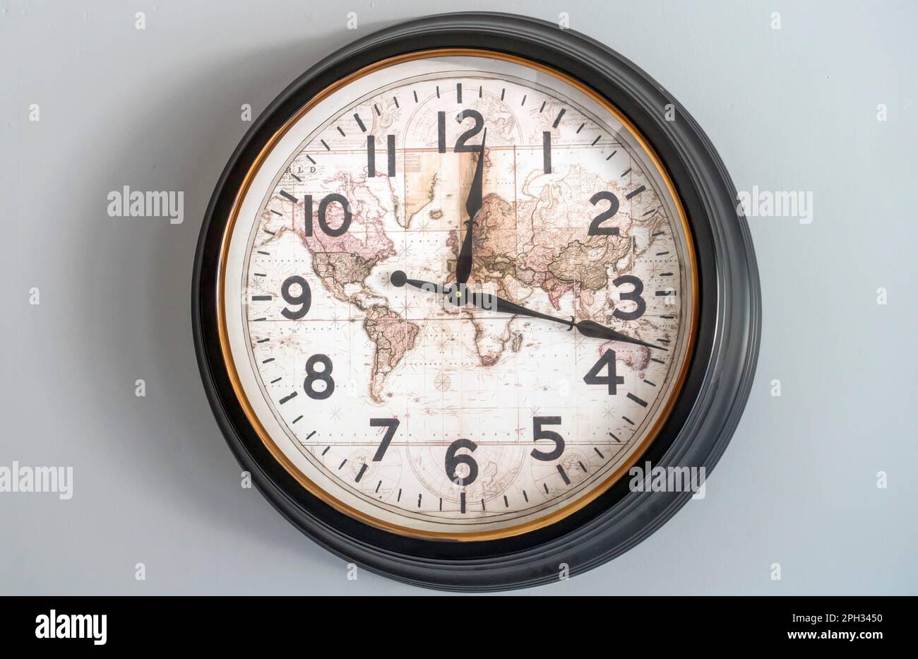 Old clock with hour and minute hands with world map dial Stock Photo