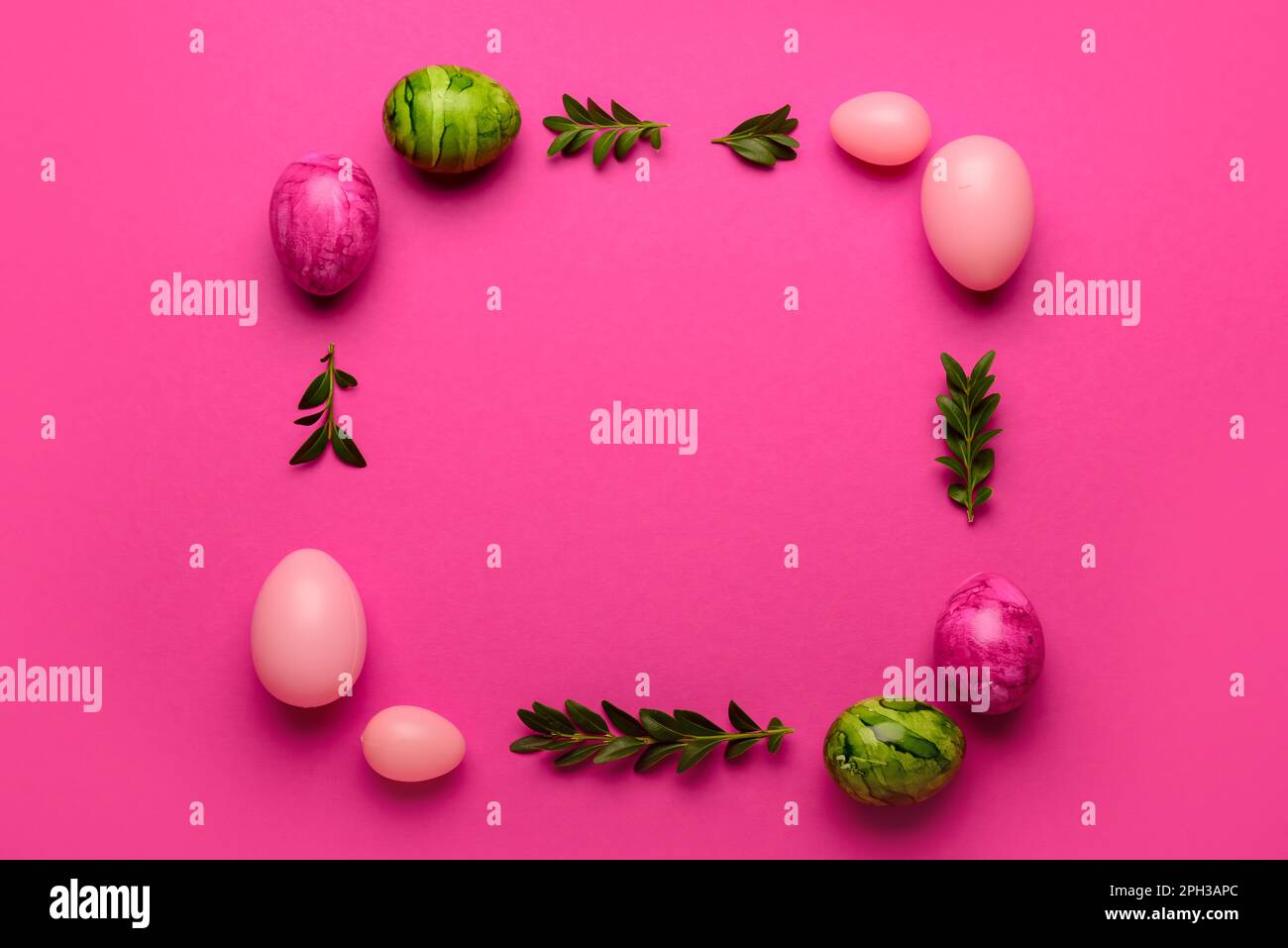 Frame made of Easter eggs and plant leaves on pink background Stock ...