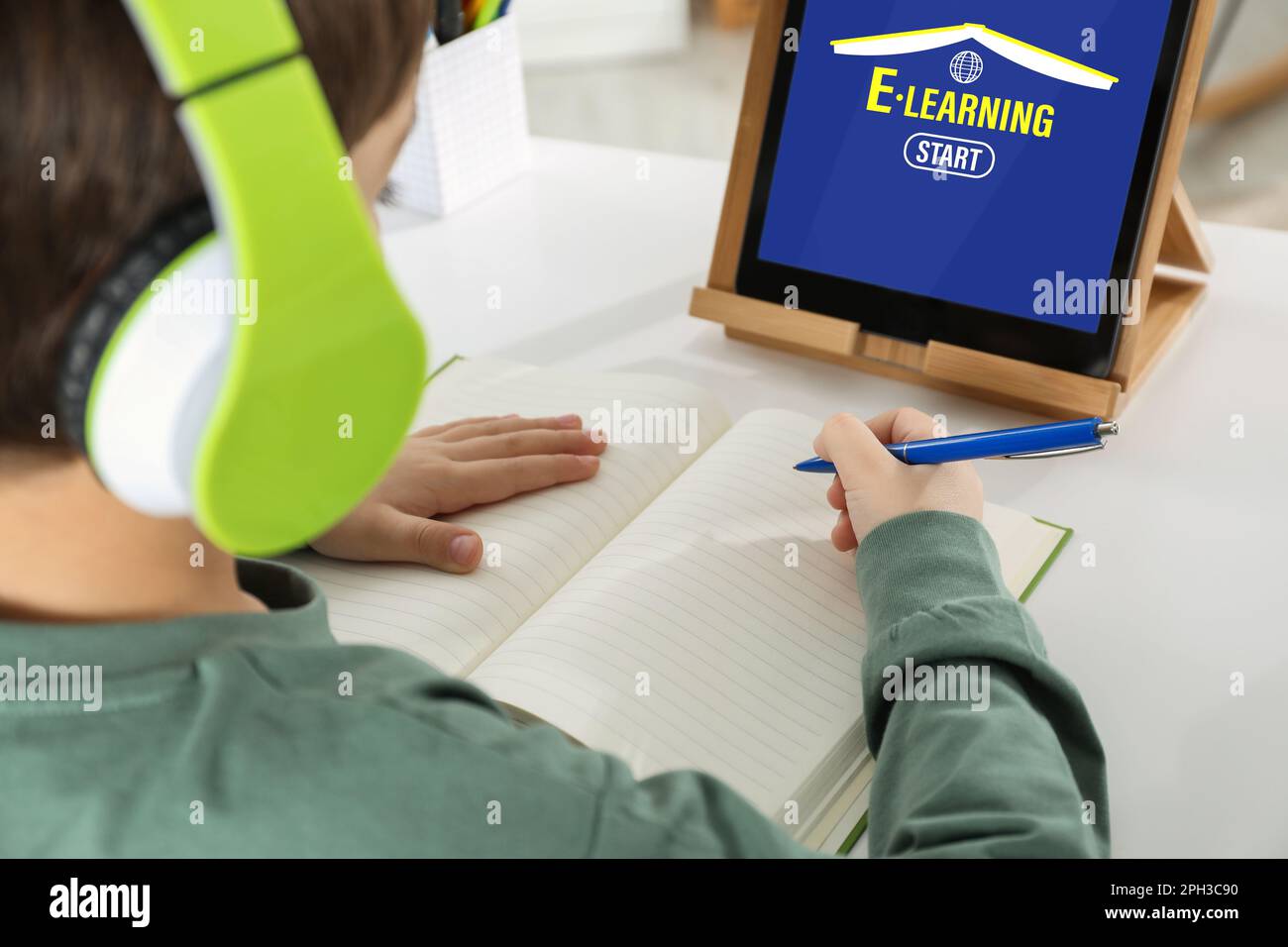 Cute little boy with modern tablet studying online at home, closeup. E ...