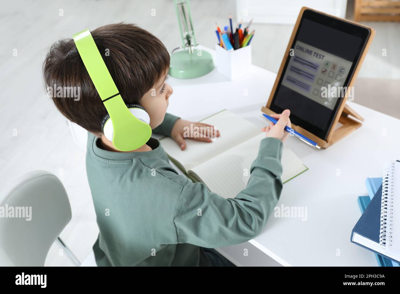 Cute little boy with modern tablet studying online at home. E-learning ...