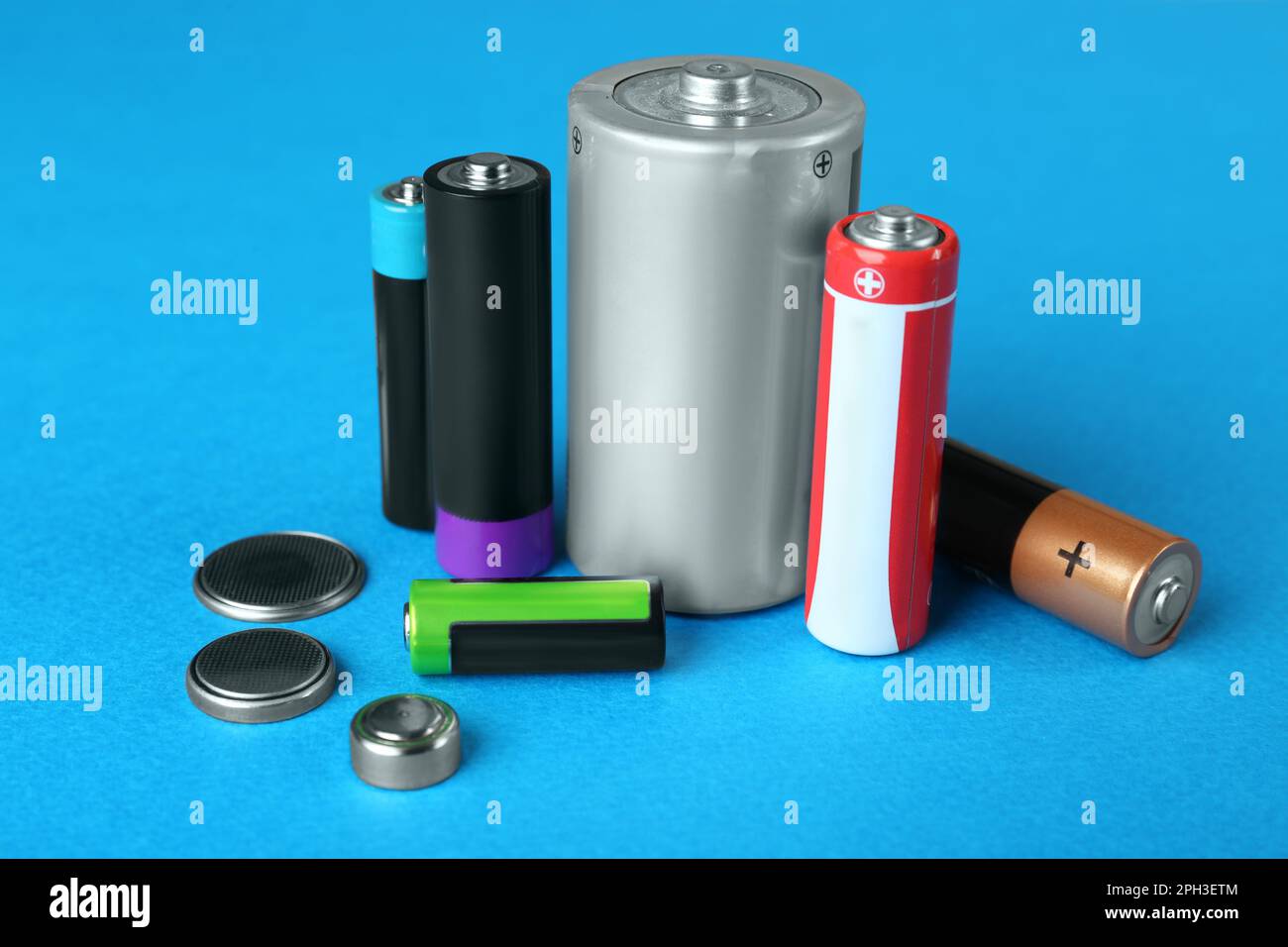 Different types of batteries on light blue background Stock Photo Alamy