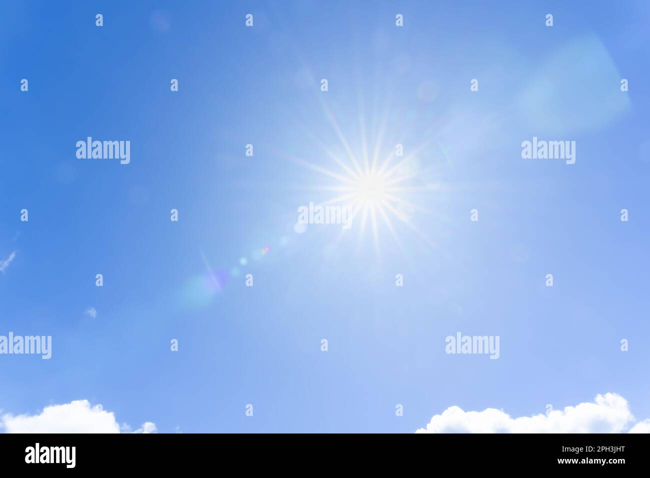 Sun flare in blue sky with lens flare effect background Stock Photo - Alamy