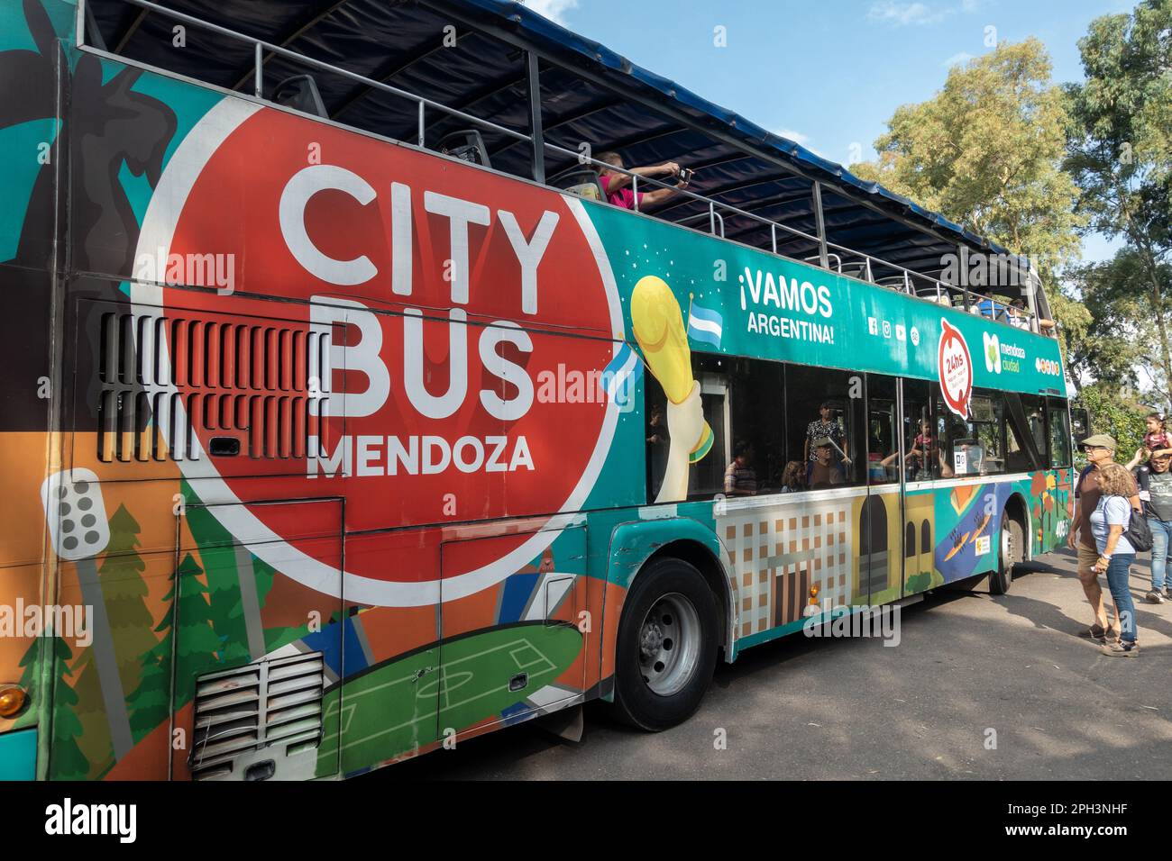 Double Deck Platform Bus with Tourists Entering onboard in Mendoza, Argentina. Convenient Guided Transportation for City Tour Hop On Off Sightseeing Stock Photo